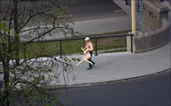 A man carries a rubber woman